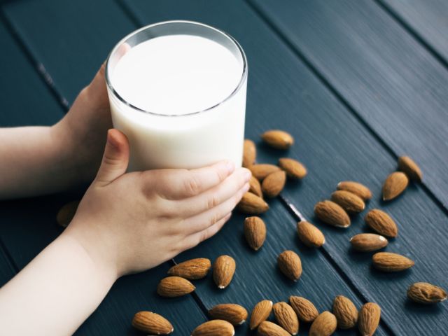 Child holding a glass of almond milk